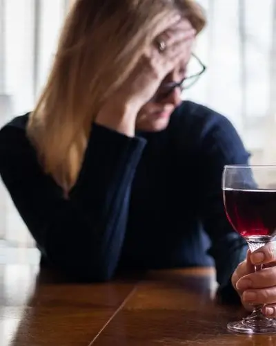 Woman drinking wine head in hand